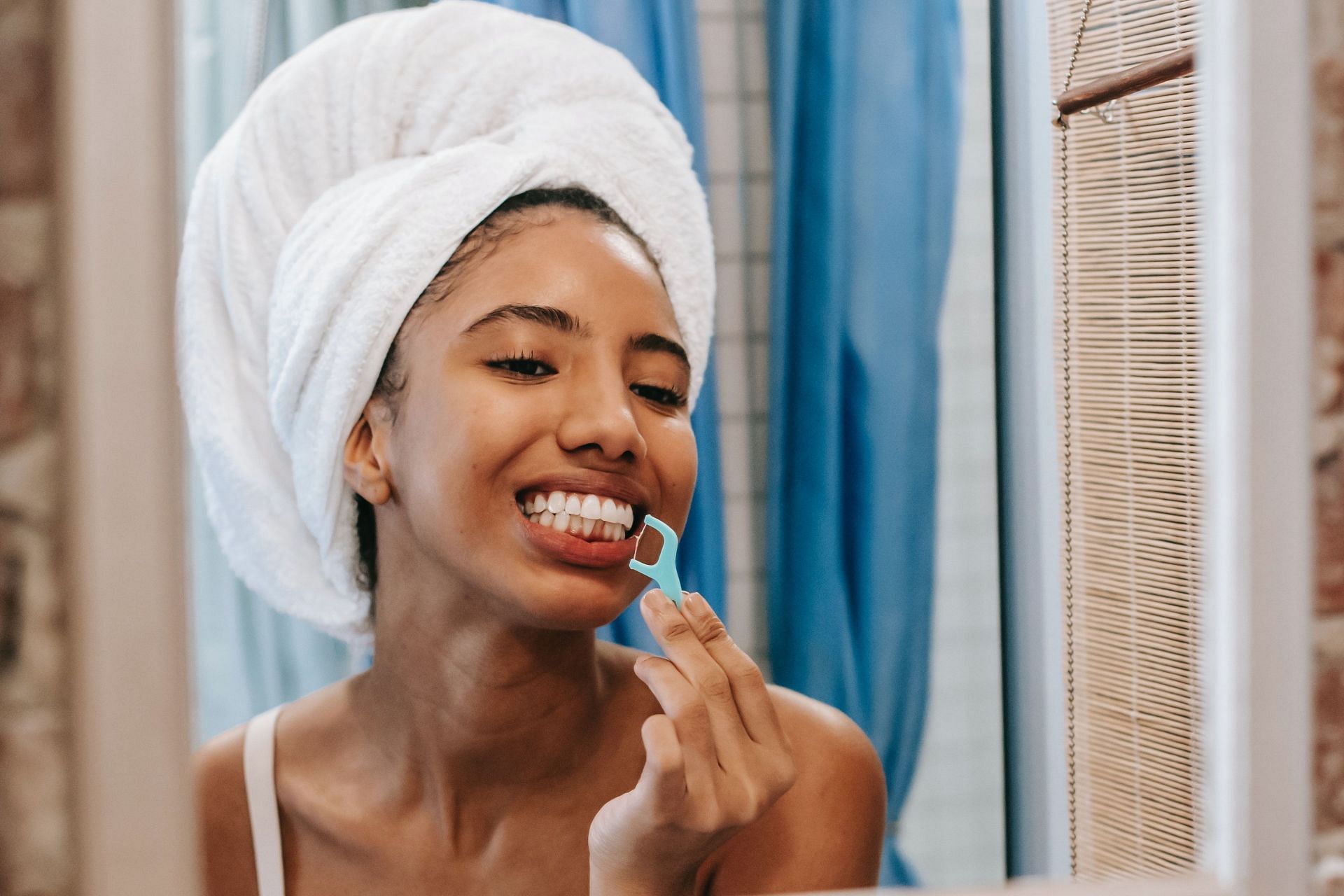 Flossing teeth helps to remove plaque, keeping your teeth in good health (Image via Pexels @Sora Shimazaki)